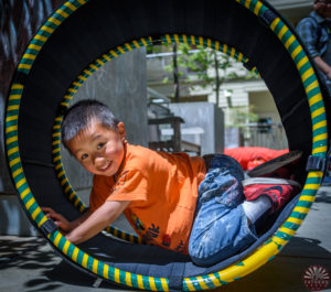 Asian boy in tube on playgorund Asian boy in tube on playgorund